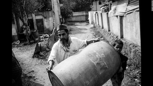 
Một người đàn ông mang thùng ra đựng nước khi chiếc xe bồn mang nước đến Latur, Ấn Độ.
