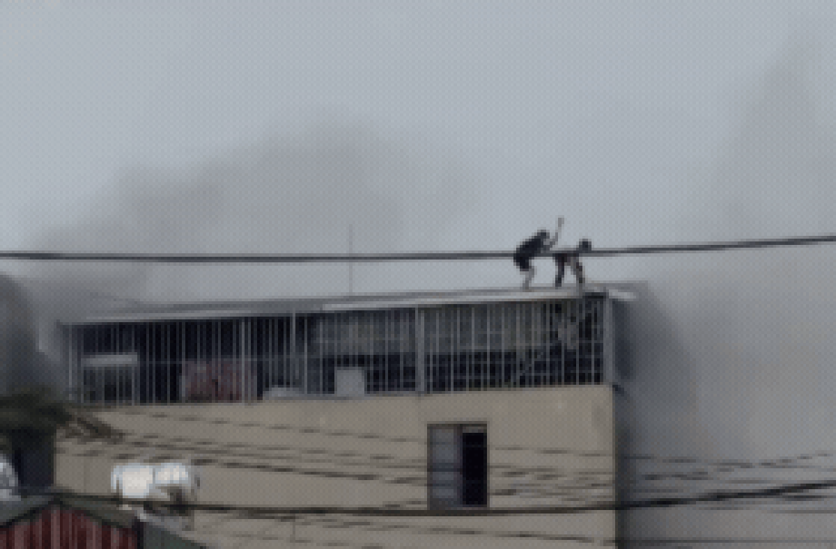 CLIP: Cận cảnh khoảnh khắc nghẹt thở khi 2 người đàn ông phá mái tôn mở đường sống trong đám cháy nhà 7 tầng ở Lĩnh Nam