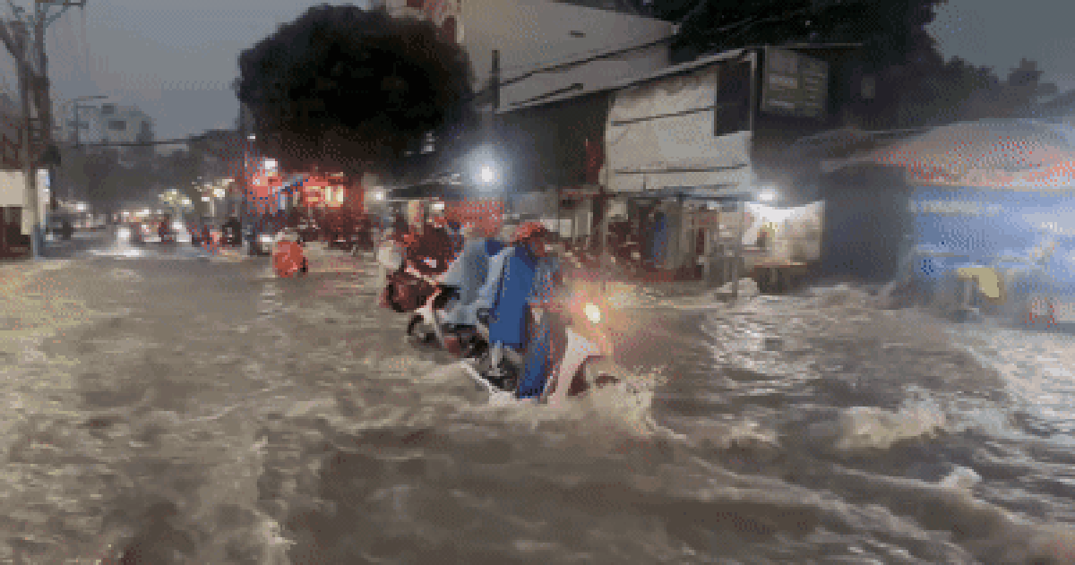 Nước chảy như thác cuốn ngã người đi xe máy ở TP HCM sau mưa lớn