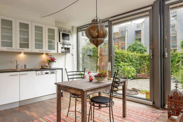 
Nhờ những tấm cửa kính rộng mở và cao sát trần phía cuối nhà mà chủ nhà có thể ngắm sân vườn từ bếp và phòng khách.

 
