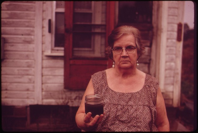 
Bà Mary Workman sống ở Steubenville, Ohio. Trên tay bà là lọ chứa loại nước ô nhiễm nghiêm trọng múc lên từ dưới giếng. Người phụ nữ này từng đệ đơn kiện công ty khai thác than gần đó vì cho rằng nó gây ô nhiễm giếng nước nhà bà. Ngày nay, nước Mỹ có những đạo luật nghiêm ngặt để bảo vệ nguồn nước ngầm khỏi bị ô nhiễm.
