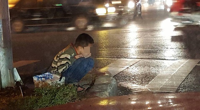 Cậu bé ăn xin ngồi bên đường giữa một chiều mưa tầm tã, nhiều người động lòng nhưng vẫn không muốn giúp? (Ảnh: Facebook Phạm Ngọc Linh)