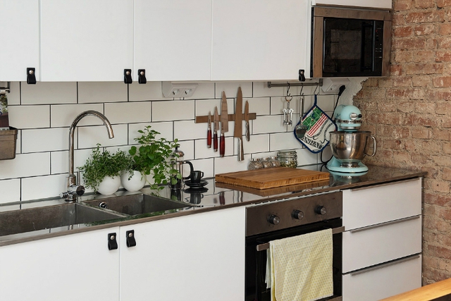 Hệ thống tủ kệ khép kín nơi nấu ăn khiến không gian bếp càng trở nên gọn đẹp. Cây xanh cũng được trồng để mang màu xanh tươi mát cho góc nấu nướng. 
