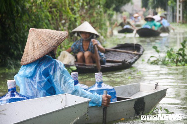 Dân vùng rốn lũ Hà Nội tấp nập chèo thuyền đi lấy nước miễn phí - Ảnh 9.