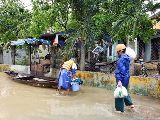 Ngập sâu cả mét, nhiều người Đà Nẵng lội nước, chèo thuyền cả km để đi chợ - Ảnh 9.