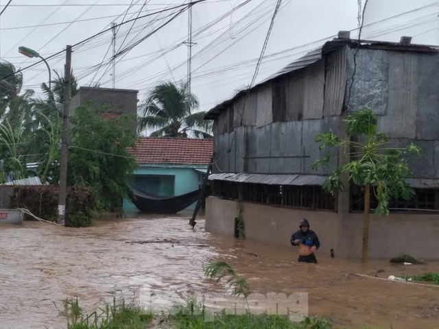 Bão tan nhưng dân phố biển Nha Trang vẫn bì bõm nơi nước ngập - Ảnh 1.