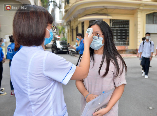 Chùm ảnh kỳ thi chưa từng có trong lịch sử: Thí sinh đeo khẩu trang kín mít, xếp hàng đo thân nhiệt đi thi THPT Quốc gia - Ảnh 2.