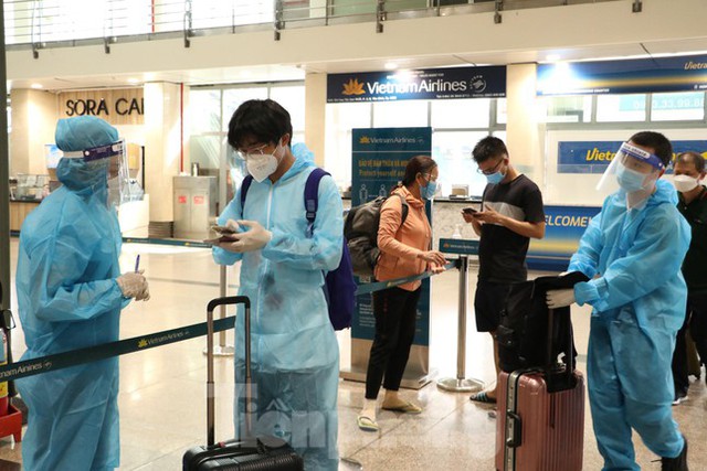 Hành khách mặc bảo hộ kín mít đến sân bay Tân Sơn Nhất ngày đầu thí điểm bay nội địa  - Ảnh 1.