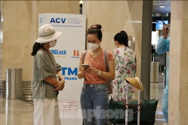 Hành khách mặc bảo hộ kín mít đến sân bay Tân Sơn Nhất ngày đầu thí điểm bay nội địa  - Ảnh 4.