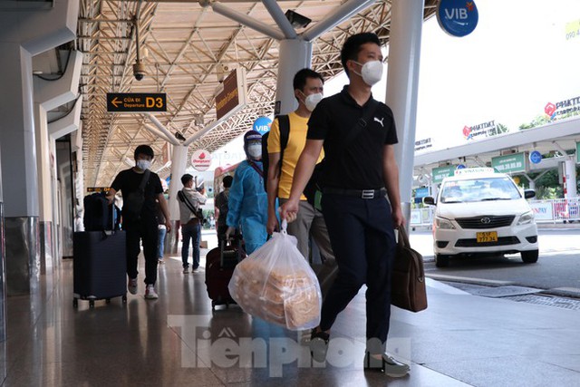 Hành khách mặc bảo hộ kín mít đến sân bay Tân Sơn Nhất ngày đầu thí điểm bay nội địa  - Ảnh 10.