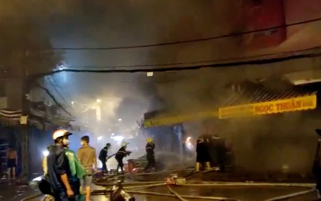 Cảnh sát dầm mưa cắt cửa sắt để dặp tắt đám cháy trong chợ Nhị Thiên Đường