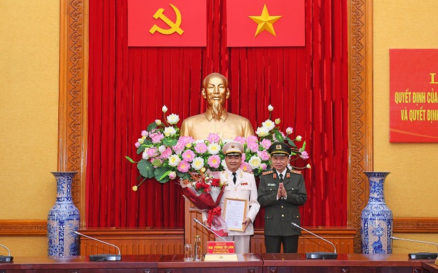 Thừa ủy quyền của Chủ tịch nước, Bộ trưởng Tô Lâm trao Quyết định và tặng hoa chúc mừng Trung tướng Nguyễn Minh Đức. (Ảnh: Mộc Trà: BCA)