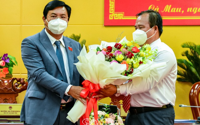 Ông Nguyễn Tiến Hải, Bí thư Tỉnh ủy, Chủ tịch HĐND tỉnh Cà Mau (trái) tặng hoa chúc mừng ông Nguyễn Minh Luân. Ảnh ( Phong Phú- Báo Cà Mau)