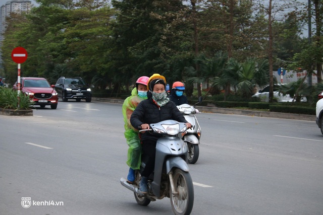 Hà Nội: Không khí lạnh bao trùm sáng đầu tuần, người dân phải mặc thêm áo mưa chống rét dù trời tạnh ráo - Ảnh 1.