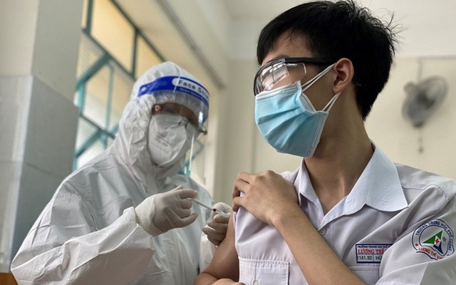 Nhân viên y tế tiêm vắc xin cho học sinh.