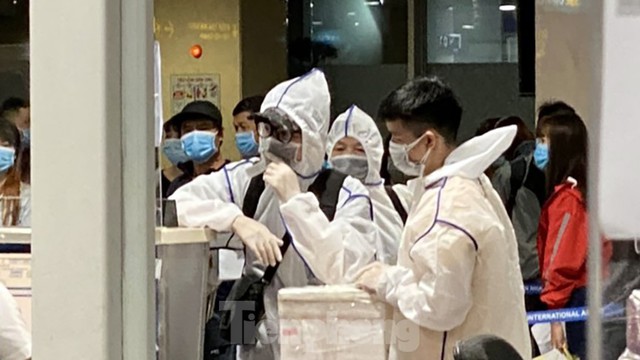 Hành khách mặc áo mưa, bảo hộ kín mít khi đi máy bay tại Tân Sơn Nhất - Ảnh 3.