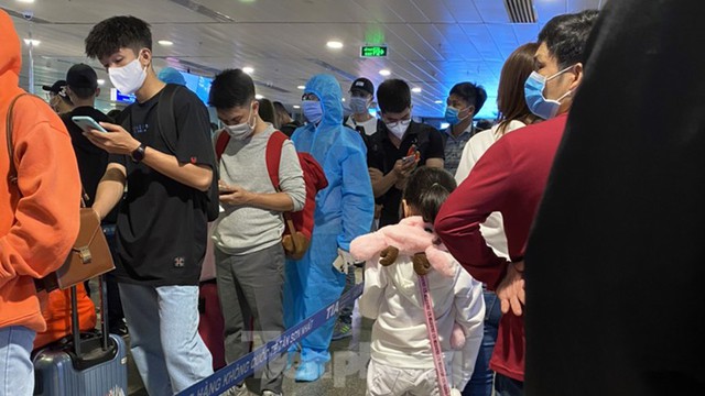 Hành khách mặc áo mưa, bảo hộ kín mít khi đi máy bay tại Tân Sơn Nhất - Ảnh 9.