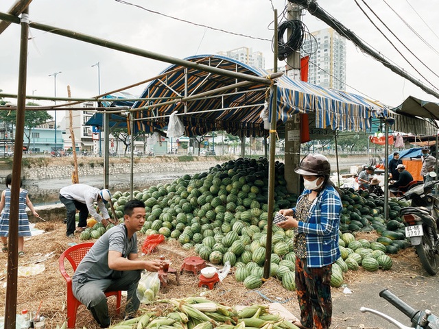 Sài Gòn chiều 30 Tết trái cây xổ đầy đường nhiều hơn cả hoa, người bán buồn thiu than vãn: Rẻ như cho mà không ai mua con ơi! - Ảnh 2.