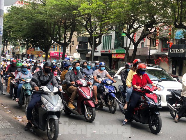 Sài Gòn nhộn nhịp trưa Mùng 1 Tết, dân đeo khẩu trang kín mít đi lễ chùa đầu năm - Ảnh 1.