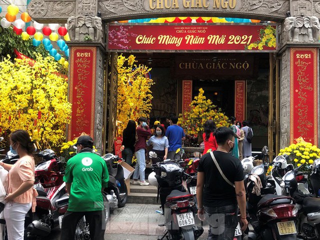 Sài Gòn nhộn nhịp trưa Mùng 1 Tết, dân đeo khẩu trang kín mít đi lễ chùa đầu năm - Ảnh 14.
