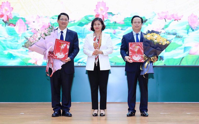 Phó Bí thư Thường trực Thành ủy Nguyễn Thị Tuyến trao quyết định, tặng hoa ông Trần Thế Cương và ông Vũ Hà
