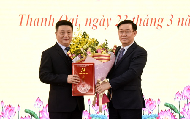 Bí thư Thành ủy Vương Đình Huệ trao Quyết định và tặng hoa chúc mừng ông Bùi Hoàng Phan ( Ảnh: Hanoi.gov.vn)