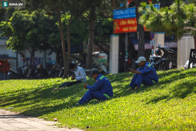  [ẢNH] Đường Sài Gòn nóng như thiêu, người dân vật vã tránh nóng ở góc cây, gầm cầu - Ảnh 6.