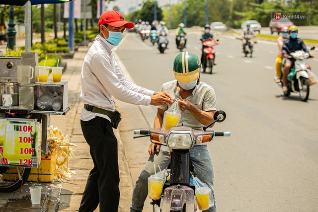 Chùm ảnh: Công nhân vật lộn với cái nóng hầm hập ở Sài Gòn, người đi đường mặc cả áo mưa tránh nắng - Ảnh 18.