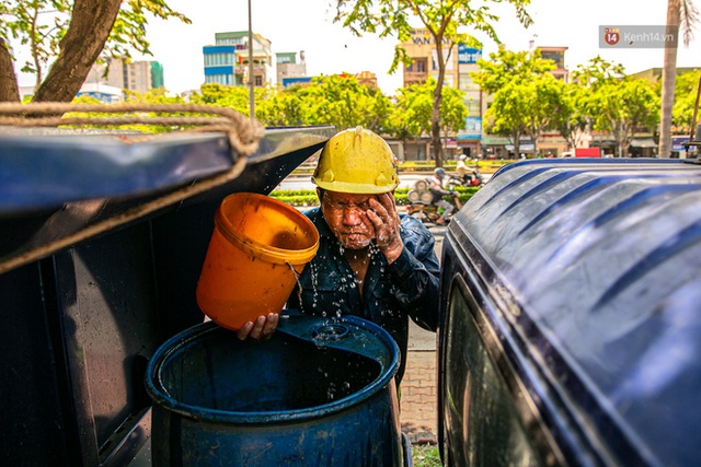 Chùm ảnh: Công nhân vật lộn với cái nóng hầm hập ở Sài Gòn, người đi đường mặc cả áo mưa tránh nắng - Ảnh 5.