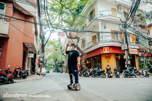 Quán phở diễn xiếc lạ nhất Hà Nội: Đội tô nước lèo nóng hổi thăng bằng trên đầu, chân lướt như bay bằng xe điện trong khu ngõ nhỏ để phục vụ khách - Ảnh 1.