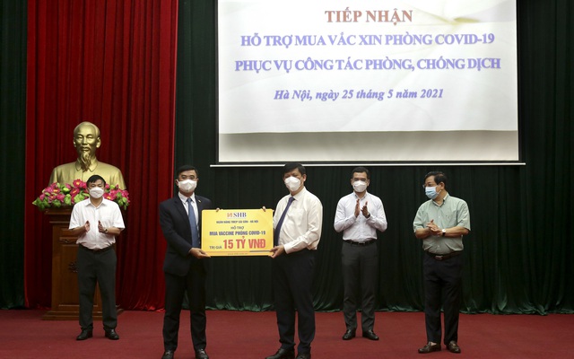 TGĐ Nguyễn Văn Lê (trái) đại diện SHB trao tặng Bộ Y tế 15 tỷ đồng hỗ trợ kinh phí mua vaccine phòng Covid-19