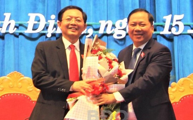 Chủ tịch UBND tỉnh Nguyễn Phi Long (phải) tặng hoa chúc mừng Chủ tịch HĐND tỉnh khóa XIII Hồ Quốc Dũng. Ảnh: N.V.TRANG