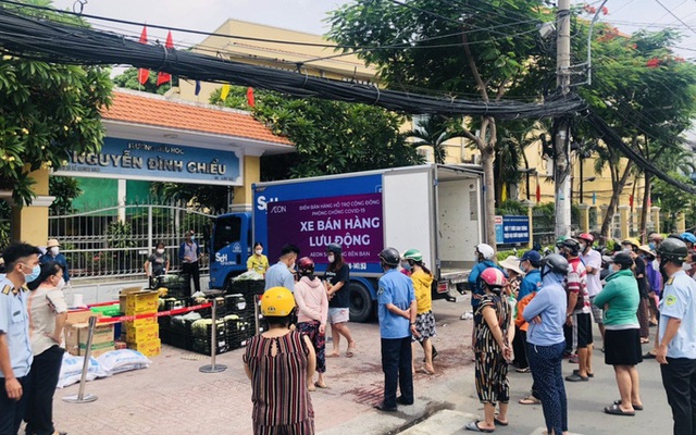 Đông đảo người dân xếp hàng chờ mua thực phẩm, rau xanh tại điểm bán hàng lưu động trước cổng trường Nguyễn Đình Chiểu, quận Bình Thạnh