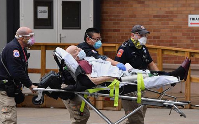 Nhân viên y tế chuyển bệnh nhân COVID-19 vào một bệnh viện ở New York City, Mỹ. Ảnh: AFP/TTXVN