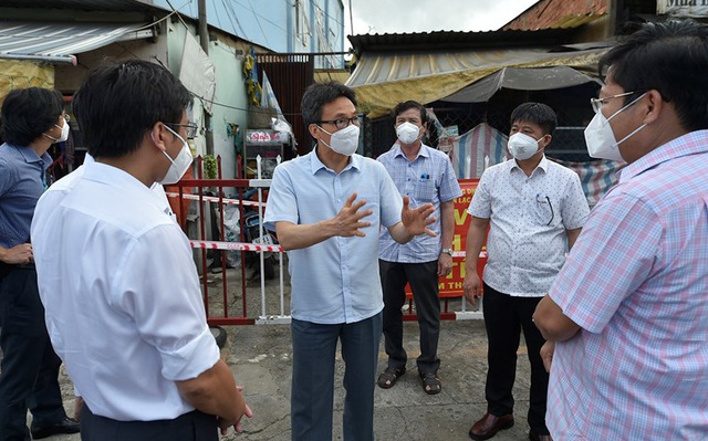 Phó Thủ tướng Vũ Đức Đam trao đổi với lãnh đạo quận Bình Tân (TPHCM) trước một khu nhà trọ công nhân đang bị phong toả, chiều 25/7. Ảnh: VGP/Đình Nam