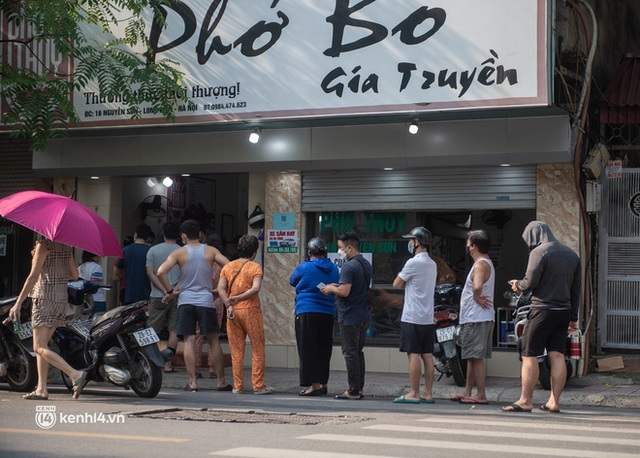 Xếp hàng dài mua đồ ăn ở Long Biên (Hà Nội): Khách mang cả cái nồi to, chủ quán làm 500 tô/ngày vẫn không đủ bán - Ảnh 1.