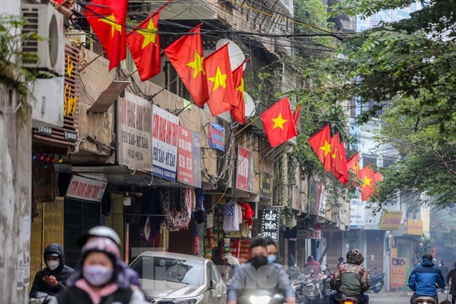  Phố phường Hà Nội đỏ thắm màu cờ ngày 29 Tết  - Ảnh 1.