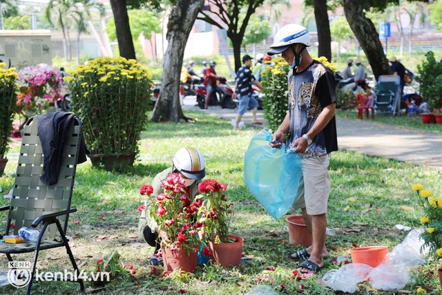 ẢNH: Sau khi tiểu thương ở Sài Gòn vứt bỏ hoa ế, nhiều người dân tranh thủ đến xin đất, lượm hoa mang về trưa 29 Tết - Ảnh 5.