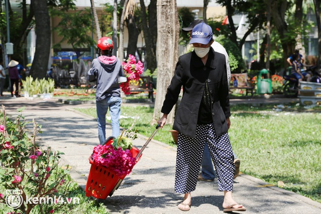 ẢNH: Sau khi tiểu thương ở Sài Gòn vứt bỏ hoa ế, nhiều người dân tranh thủ đến xin đất, lượm hoa mang về trưa 29 Tết - Ảnh 6.