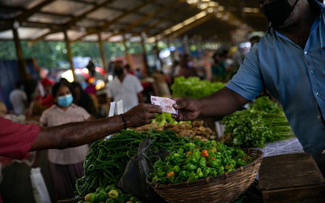 Một người đàn ông trả tiền mua rau tại chợ ở Colombo. Ảnh: Getty Images
