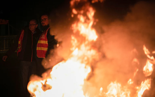 Công nhân đốt lửa trước nhà máy lọc dầu ExxonMobil để yêu cầu tăng lương. Ảnh: Lou Benoist/AFP/Getty Images