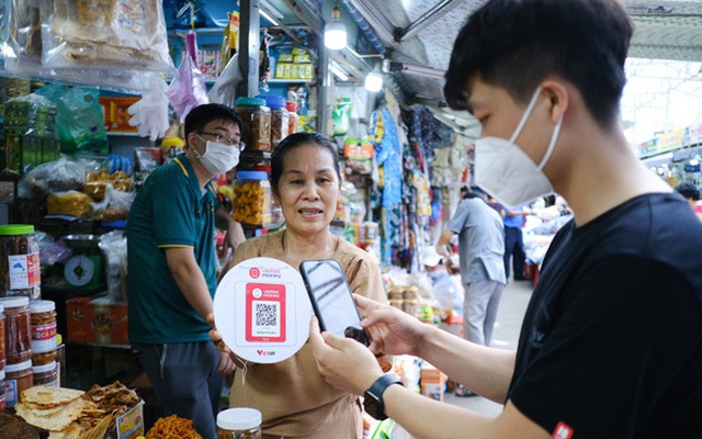 Du khách quét mã QR thanh toán khi mua sắm tại một gian hàng đặc sản ở chợ Cồn, TP Đà Nẵng - Ảnh: TẤN LỰC