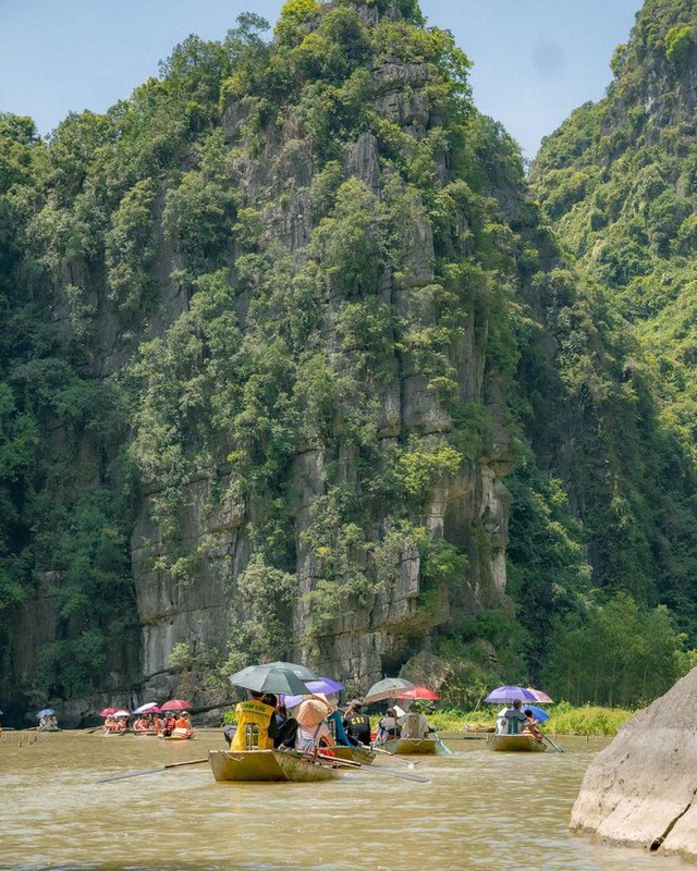 Du khách nước ngoài ngạc nhiên trước cảnh chèo thuyền bằng chân và bánh kẹo được bán trên sông ở Ninh Bình - Ảnh 1.
