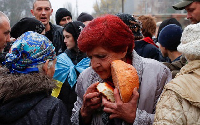 Người dân thành phố Kherson, Ukraine, nhận lương thực cứu trợ ngày 17-11 - Ảnh: REUTERS