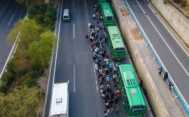 Nhân viên Foxconn bắt xe buýt đưa đón về nhà từ Trịnh Châu - Ảnh: BLOOMBERG