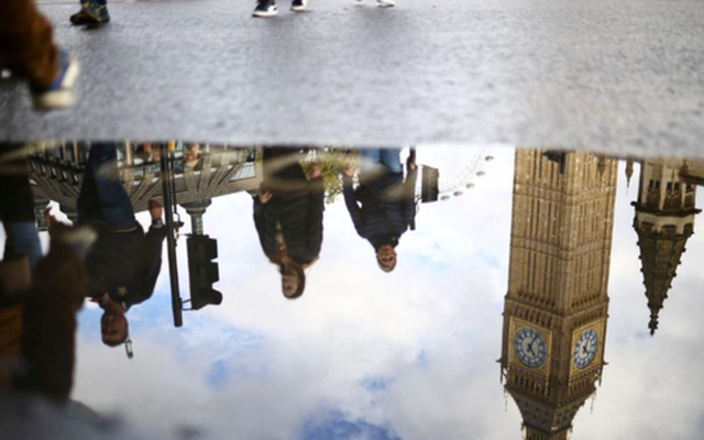 Bóng tháp đồng hồ Big Ben ở London dưới một vũng nước. (Ảnh: Reuters)