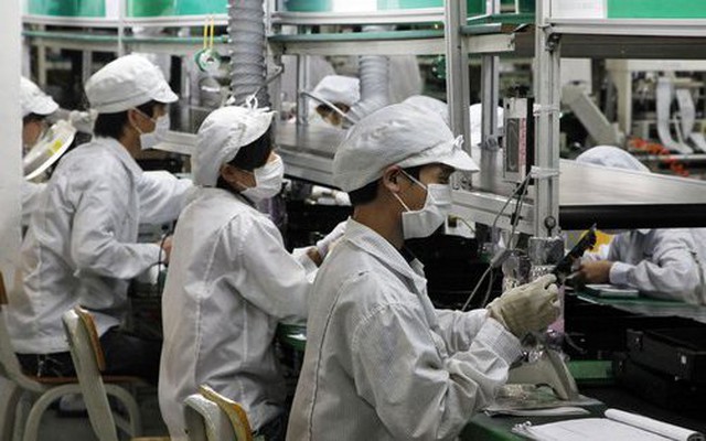 Các công nhân làm việc trên dây chuyền lắp ráp của Foxconn (Ảnh: Bloomberg)