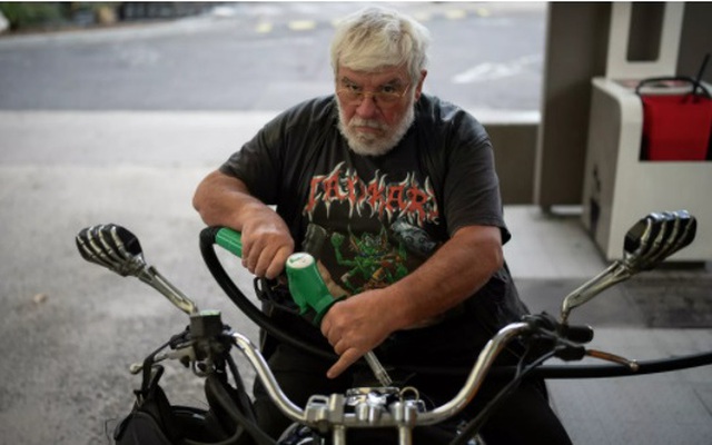 Một người lái xe máy đổ xăng tại trạm nhiên liệu. Ảnh: AP