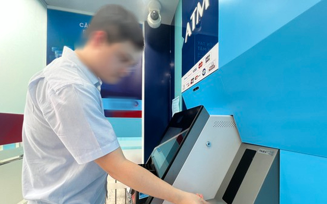 Người dân rút tiền bằng thẻ CCCD gắn chip tại cây ATM trên địa bàn quận Hoàn Kiếm (Hà Nội). (Ảnh: NLĐ)