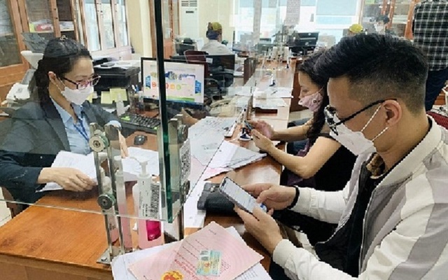 Cán bộ Trung tâm Hành chính công TP Hạ Long hướng dẫn công dân nộp hồ sơ trực tuyến trên cổng Dịch vụ công (ảnh báo QN)